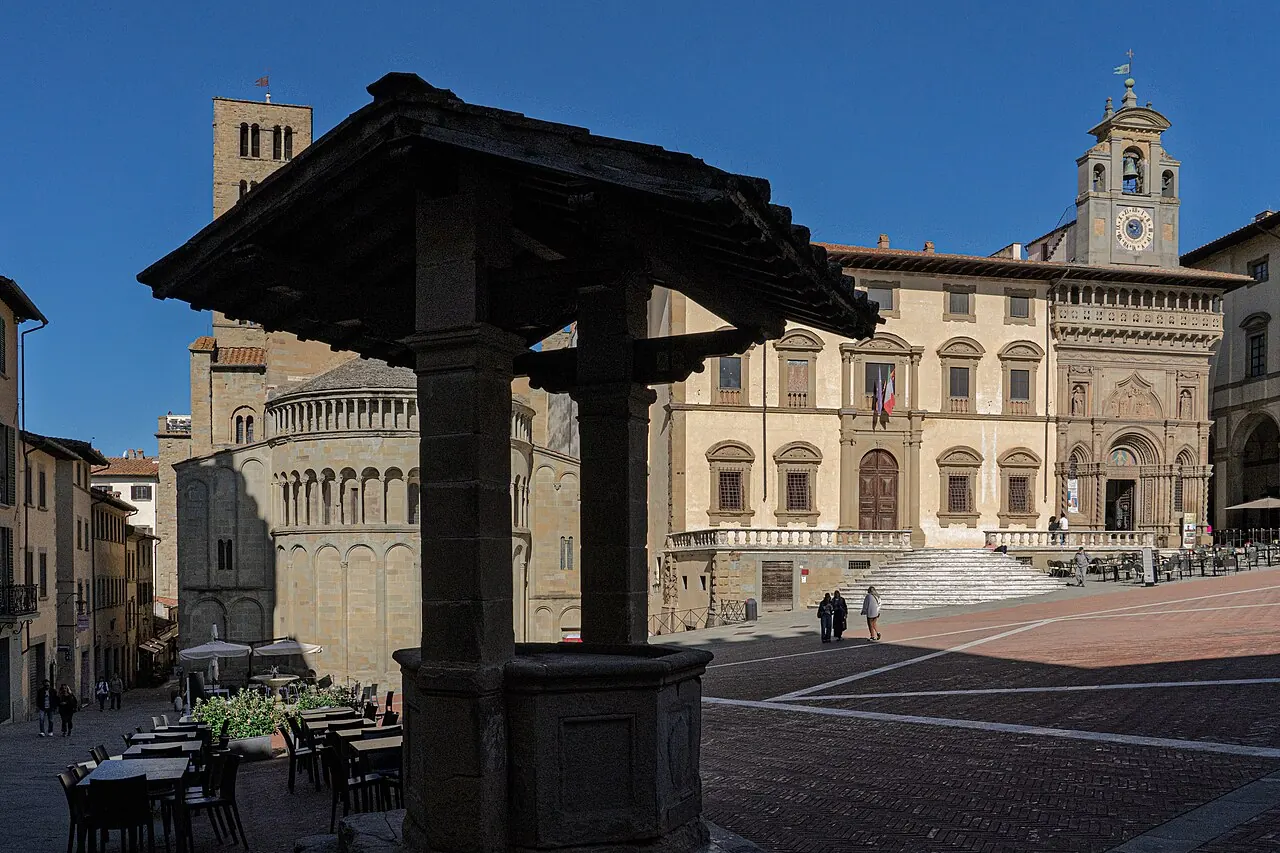 La Pieve di Santa Maria vista da Piazza Grande, con il pozzo e la facciata a logge